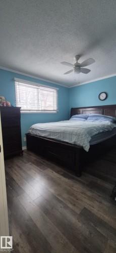 This property offers a room with wood-style flooring, a window with blinds, and a ceiling fan - 5420 40 Avenue, Wetaskiwin, AB - Indoor Photo Showing Bedroom
