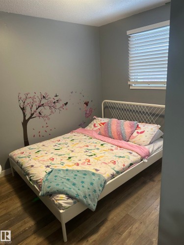 This room features wood-style flooring and a window with blinds - 5420 40 Avenue, Wetaskiwin, AB - Indoor Photo Showing Bedroom