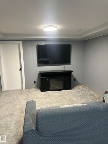 This room features soft carpeting, light gray walls, and recessed lighting - 5420 40 Avenue, Wetaskiwin, AB - Indoor