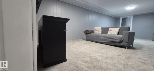 This room features light grey carpeting, paneling on the walls, and a recessed ceiling light fixture - 5420 40 Avenue, Wetaskiwin, AB - Indoor