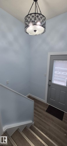Entryway featuring light blue walls, hardwood flooring, and a modern ceiling light fixture - 5420 40 Avenue, Wetaskiwin, AB - Indoor Photo Showing Other Room