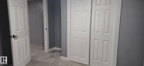 The room features carpeted flooring, gray walls, and white trim - 5420 40 Avenue, Wetaskiwin, AB - Indoor Photo Showing Other Room