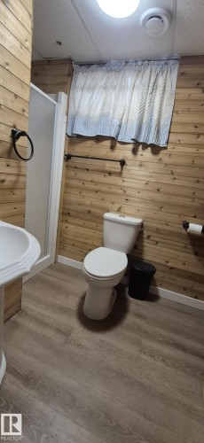 Bathroom featuring wood paneling, a pedestal sink, and a shower stall - 5420 40 Avenue, Wetaskiwin, AB - Indoor Photo Showing Bathroom
