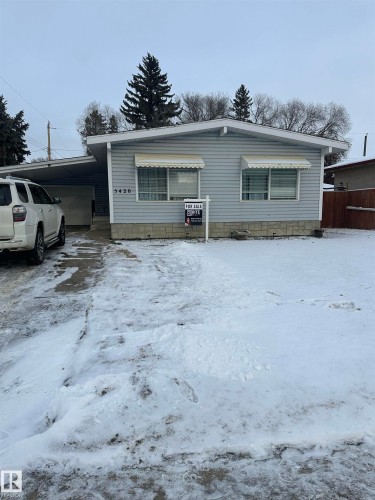 The property features light blue siding, a covered carport, and a gravel driveway - 5420 40 Avenue, Wetaskiwin, AB - Outdoor