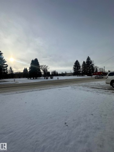The property features a large open outdoor space, covered in snow, with a paved road visible in the foreground - 5420 40 Avenue, Wetaskiwin, AB - Outdoor With View