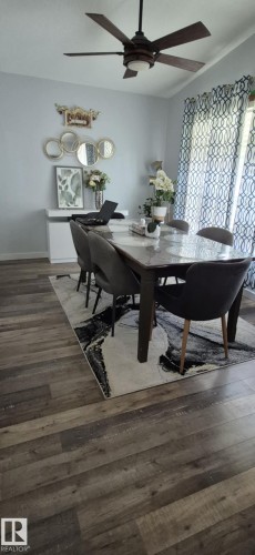 This room features a ceiling fan, wood-style flooring, and light-colored walls - 5420 40 Avenue, Wetaskiwin, AB - Indoor