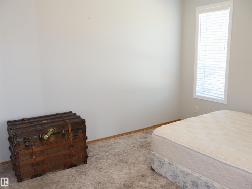 Room with light gray walls, white trim, and light brown baseboards - 5802 52 Avenue, Barrhead, AB - Indoor Photo Showing Bedroom