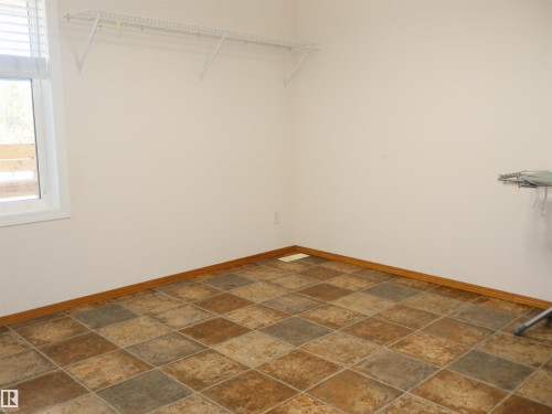 Room featuring multi-tone square tile flooring and white baseboards - 5802 52 Avenue, Barrhead, AB - Indoor