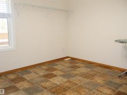 Room featuring multi-tone square tile flooring and white baseboards - 