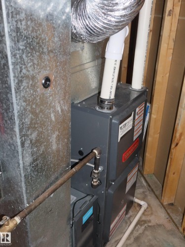 Contemporary furnace unit with associated ductwork and piping - 5802 52 Avenue, Barrhead, AB - Indoor Photo Showing Basement