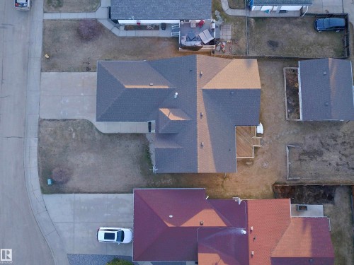 Property featuring a large footprint with a multi-gabled roofline, a rear deck, a concrete driveway, and a front walkway - 5802 52 Avenue, Barrhead, AB - Outdoor