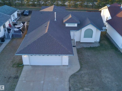 Contemporary residence featuring a two-car garage, concrete driveway, and a shingled roof - 5802 52 Avenue, Barrhead, AB - Outdoor