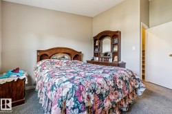 Carpeted bedroom featuring neutral wall tones and a built-in wood headboard - 
