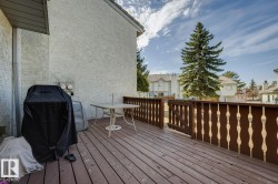 Spacious wooden deck featuring a decorative wood railing and stucco exterior - 