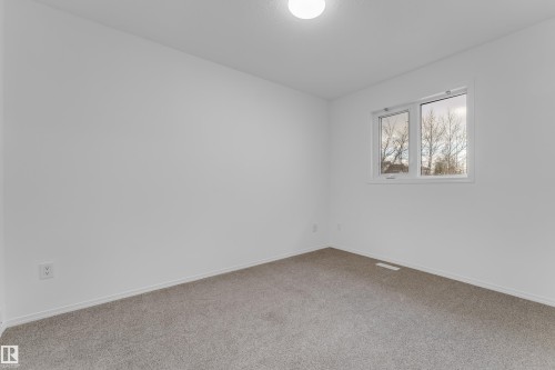 Spacious room featuring neutral carpeting, white baseboards, a single window, and a flush-mount ceiling light fixture - 4103 37A Avenue, Edmonton, AB - Indoor Photo Showing Other Room