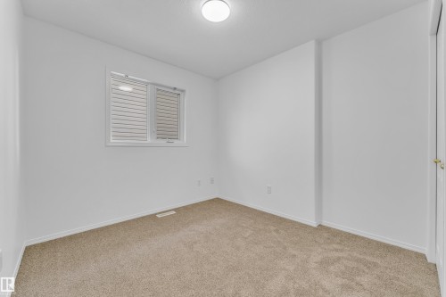 Carpeted room featuring a white interior paint scheme, a window with horizontal blinds, and a flush mount ceiling light fixture - 4103 37A Avenue, Edmonton, AB - Indoor Photo Showing Other Room