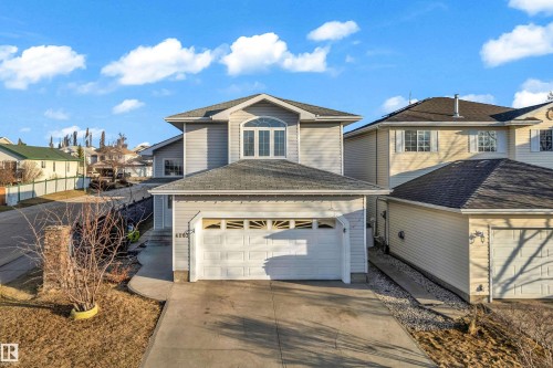 Two-story home with light grey siding, an arched window feature, an attached two-car garage, and a concrete driveway - 4103 37A Avenue, Edmonton, AB - Outdoor