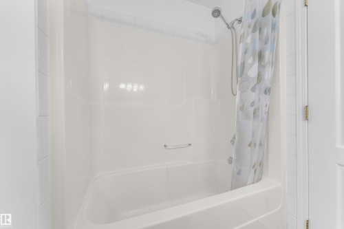 White fiberglass tub and shower combination with a flexible shower head fixture - 4103 37A Avenue, Edmonton, AB - Indoor Photo Showing Bathroom