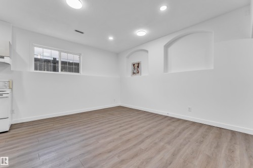 Open-concept living space featuring wood-finish flooring, recessed lighting, and a window with horizontal panes - 4103 37A Avenue, Edmonton, AB - Indoor