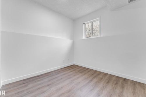 Room featuring wood-finish flooring, crisp white walls, and a recessed window - 4103 37A Avenue, Edmonton, AB - Indoor Photo Showing Other Room