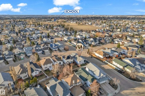 Residential neighborhood featuring an array of single-family homes with diverse architectural styles, paved streets, and a school building in the distance - 4103 37A Avenue, Edmonton, AB - Outdoor With View