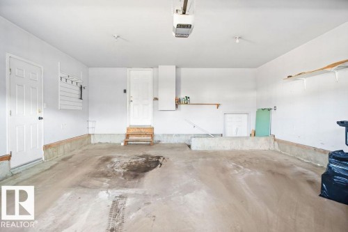 Spacious garage with a concrete floor and white painted walls - 4103 37A Avenue, Edmonton, AB - Indoor Photo Showing Garage