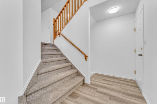 Entryway featuring wood-finish flooring, a white paneled door, and a flush-mount ceiling light - 4103 37A Avenue, Edmonton, AB - Indoor Photo Showing Other Room