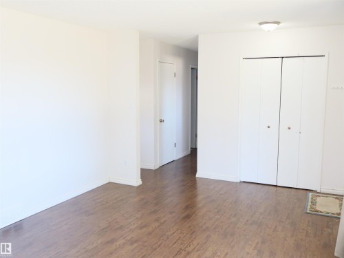 Expansive room featuring wood-finish flooring, crisp white walls, and a ceiling-mounted light fixture - 4934 49 Avenue, Barrhead, AB - Indoor Photo Showing Other Room
