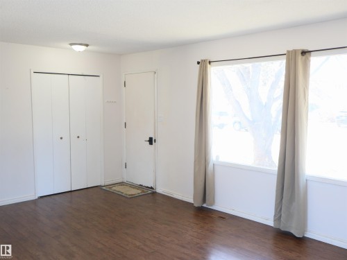 Interior space featuring wood-finish flooring, white walls, and a large window with natural light - 4934 49 Avenue, Barrhead, AB - Indoor Photo Showing Other Room