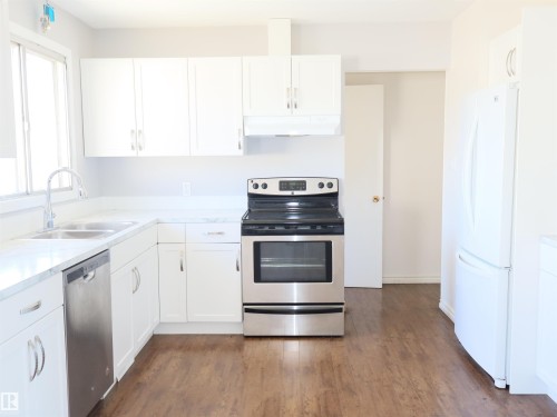 Modern kitchen featuring white cabinetry, a stainless steel range, and a stainless steel dishwasher - 4934 49 Avenue, Barrhead, AB - Indoor Photo Showing Kitchen With Double Sink