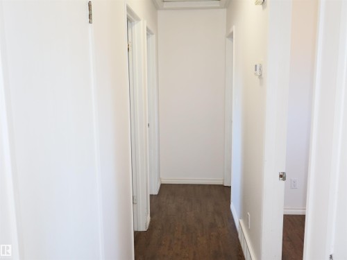 Corridor featuring wood-finish flooring, white walls, and white baseboards - 4934 49 Avenue, Barrhead, AB - Indoor Photo Showing Other Room