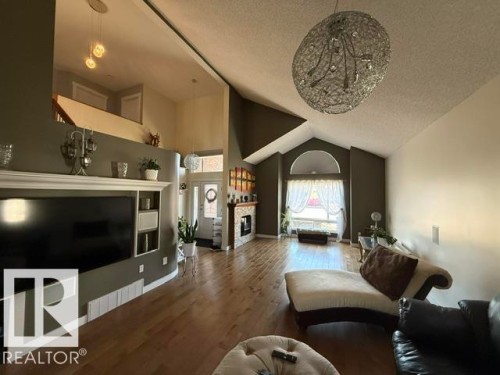 Vaulted ceilings featuring a decorative chandelier and wood-finish flooring - 356 Weber Way, Edmonton, AB - Indoor Photo Showing Living Room