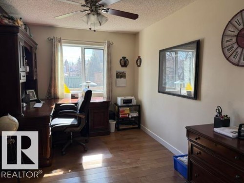 Wood-finish flooring throughout, featuring a double-paned window with curtain rods, and a ceiling fan with integrated lighting - 356 Weber Way, Edmonton, AB - Indoor Photo Showing Office