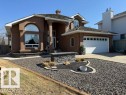 Stucco exterior with stone accents, featuring a prominent arched window and a two-car garage - 356 Weber Way, Edmonton, AB  - Outdoor 