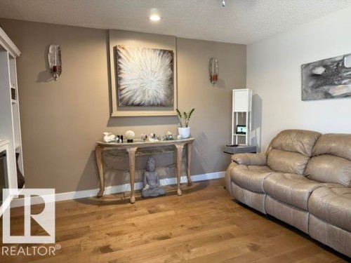 Warm wood-finish flooring complements the neutral wall tones - 356 Weber Way, Edmonton, AB - Indoor Photo Showing Living Room