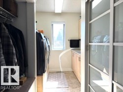 Dedicated laundry room featuring light wood-finish cabinetry, a single basin sink, and a window for natural light - 