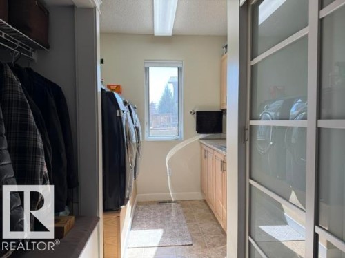 Dedicated laundry area featuring a window, light-toned cabinetry, a countertop, and recessed lighting - 356 Weber Way, Edmonton, AB -  With Exterior