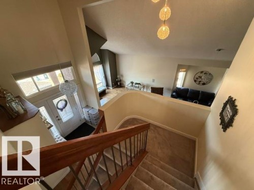Staircase with wood-finish handrail and carpeted treads - 356 Weber Way, Edmonton, AB - Indoor Photo Showing Other Room