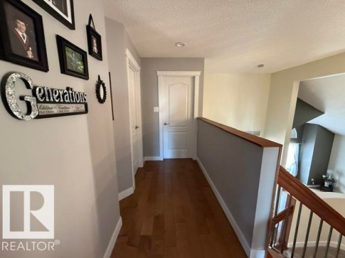 Second-story hallway featuring wood-finish flooring, light gray walls, and white trim - 356 Weber Way, Edmonton, AB - Indoor Photo Showing Other Room