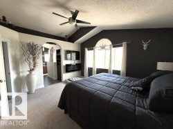 Vaulted ceilings with a ceiling fan, arched doorway, and bay window - 