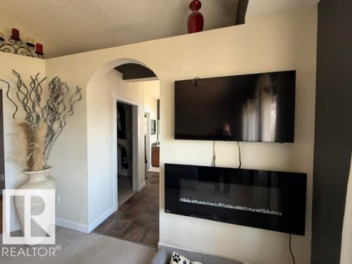 Integrated wall-mounted electric fireplace with decorative glass media - 356 Weber Way, Edmonton, AB - Indoor With Fireplace