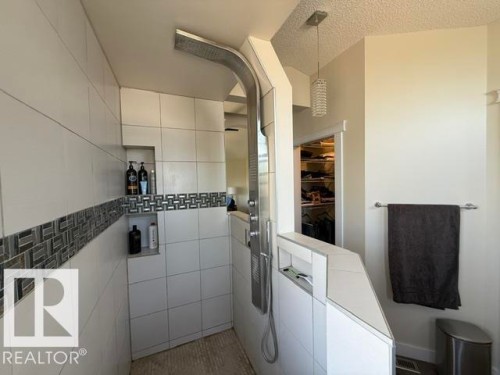 Tiled shower with a built-in niche, decorative mosaic tile band, and a multi-function shower system - 356 Weber Way, Edmonton, AB - Indoor