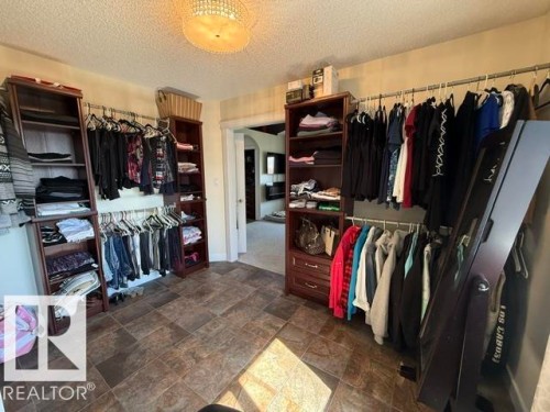 Spacious walk-in closet featuring extensive built-in shelving, hanging rods, and tile flooring - 356 Weber Way, Edmonton, AB - Indoor Photo Showing Other Room