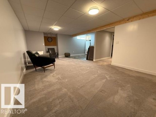 Spacious room with gray wall paint and white trim, featuring plush gray carpet flooring - 356 Weber Way, Edmonton, AB - Indoor