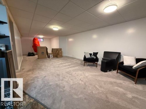 Spacious room featuring light gray carpet, white painted walls, and a drop ceiling with recessed lighting - 356 Weber Way, Edmonton, AB - Indoor