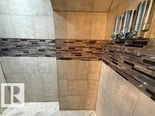 Tiled shower enclosure featuring a mosaic accent band, light-toned wall tiling, and a small-format tile floor - 356 Weber Way, Edmonton, AB - Indoor Photo Showing Bathroom