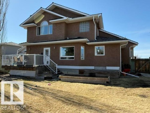 Rear exterior featuring a brown stucco finish and a multi-level deck with white railing - 356 Weber Way, Edmonton, AB - Outdoor
