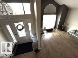 Foyer with a paneled entry door featuring decorative glass and sidelights - 