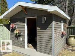 Detached outbuilding with horizontal siding, a white soffit, and a light-colored trim - 
