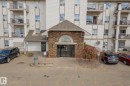 Building entrance featuring stone veneer, a covered portico, and a prominent arched window above the main doors - 1306 330 Clareview Station Drive, Edmonton, AB  - Outdoor 